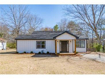 Charming renovated home showcasing a freshly painted exterior, inviting front porch and manicured lawn at 8176 Camp St, Douglasville, GA 30134