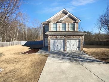 Charming two-story brick home with a two-car garage and well-manicured lawn at 5735 Hedge Brook Dr, Cumming, GA 30028