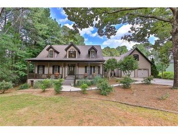 Charming home boasts a front porch, lush landscaping, and attached two car garage at 1230 Mars Hill Nw Rd, Acworth, GA 30101