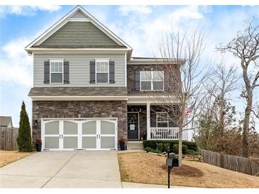 Charming two-story home with stone accents, neutral siding, large driveway, and manicured landscaping at 213 Augusta Walk, Canton, GA 30114