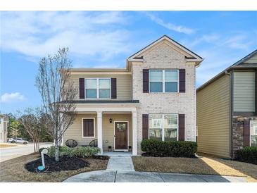 Charming two-story home with brick and siding, complemented by a cozy front porch and manicured landscaping at 855 Venture Sw Way, Atlanta, GA 30331