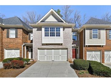 Charming townhome featuring a brick facade, a two-car garage, and a well-maintained lawn at 2349 Harshaw Ave, Lawrenceville, GA 30043