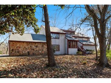 Charming exterior view of a two-story home with a stone accent wall and mature trees at 250 Bruton Way, Atlanta, GA 30342