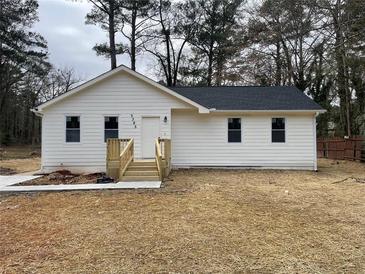 Charming single-story home with new white siding, black roof, and a wood porch at 5385 Booker T Dr, Morrow, GA 30260