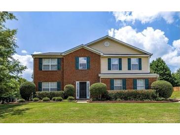 Charming two-story home featuring a brick facade, well-manicured lawn, and colorful landscaping at 2974 Michelle Lee Dr, Dacula, GA 30019