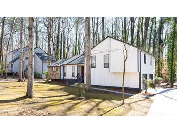 Charming home boasts updated siding and dark trim accents, surrounded by beautiful mature trees at 5199 Mainstreet Park Dr, Stone Mountain, GA 30088