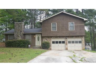 Charming two-story home featuring stone accents, a two-car garage, and a well-maintained front yard at 7356 Caribou Trl, Riverdale, GA 30296