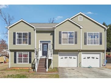 Charming split-level home featuring light-green siding, black shutters, and a convenient two-car garage at 760 Josh Ln, Lawrenceville, GA 30045