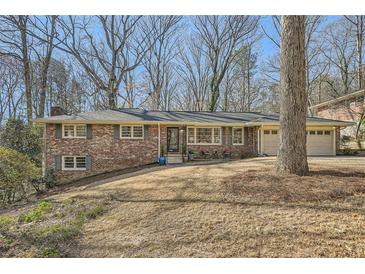 Charming brick ranch-style home featuring a well-manicured front lawn and a two-car garage at 4279 Castle Pines Ct, Tucker, GA 30084