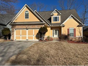 Charming yellow home with a stone-accented facade and well-maintained lawn at 9996 Village South Dr, Douglasville, GA 30135