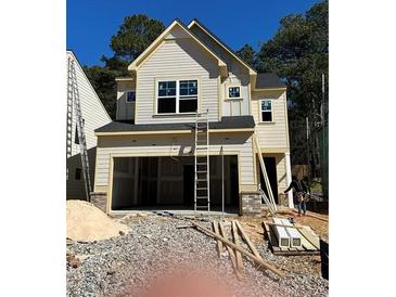 New two-story home featuring a two-car garage and light yellow siding, currently under construction at 3037 Abelia Dr, Buford, GA 30519