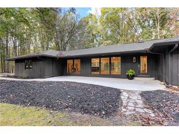 Charming one-story home featuring a modern design, large windows, and lush landscaping at 150 Melody Ln, Fayetteville, GA 30215