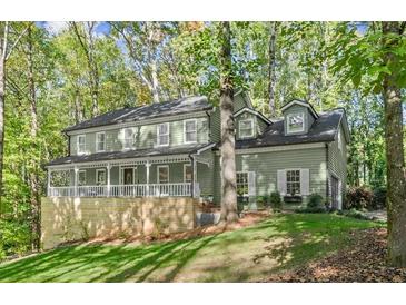 Charming two-story home with a welcoming front porch and a well-manicured lawn at 275 Waverly W Trce, Roswell, GA 30075