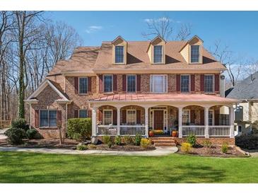 Charming brick two-story home with a welcoming front porch and manicured lawn at 1043 Sugar Pike Way, Canton, GA 30115