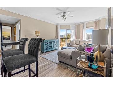 Bright living room featuring stylish furnishings, a ceiling fan, and sliding glass doors to a private balcony at 1 Biscayne Nw Dr # 804, Atlanta, GA 30309