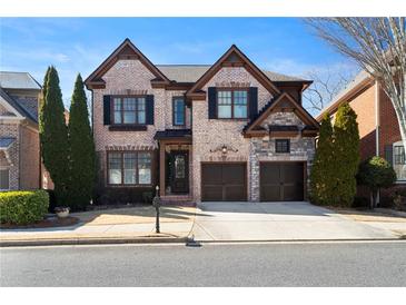 Beautiful brick home featuring a two-car garage, manicured landscaping, and a welcoming front entrance at 230 Society St, Alpharetta, GA 30022