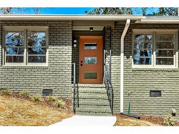 Charming brick home featuring a stylish front door and manicured landscaping at 2569 Woodhill Ln, Atlanta, GA 30344