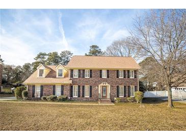 Charming brick two-story home with a well-manicured lawn and classic black shutters at 4837 Mystere Cir, Lilburn, GA 30047