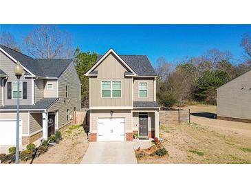 Charming two-story home featuring a well-manicured lawn, single-car garage and neutral-colored exterior at 375 Milton Dr, Covington, GA 30016