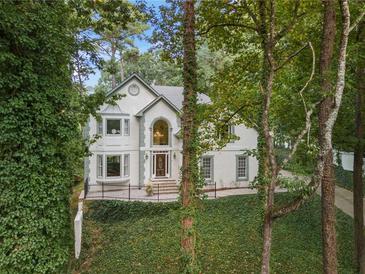 Charming two-story traditional home with manicured landscaping and mature trees at 9570 Huntcliff Trce, Atlanta, GA 30350
