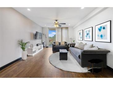 Bright living room with hardwood floors, ceiling fan, comfortable seating, and access to a balcony at 1501 Clairmont Rd # 1027, Decatur, GA 30033