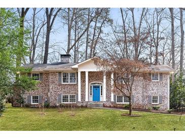 Charming brick home with a bright blue front door and a well-manicured lawn at 3911 Ivy Ne Rd, Atlanta, GA 30342