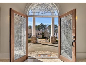 Grand entrance featuring decorative glass doors and view of circular driveway and landscaped front yard at 426 Lanesborough Dr, Marietta, GA 30064