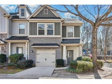 Charming townhome with a one-car garage, brick accents, and manicured landscaping at 1100 N North Village Drive Dr, Decatur, GA 30032