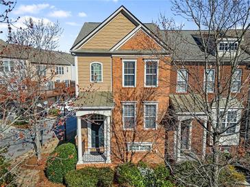 Charming brick townhome with a covered front porch and well-maintained landscaping at 4883 Seldon Se Way, Smyrna, GA 30080