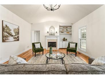 Bright living room featuring a fireplace, hardwood floors, and a vaulted ceiling at 2704 Loring Nw Rd, Kennesaw, GA 30152