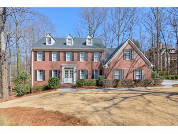 Classic brick home featuring symmetrical design, black shutters, and a well-manicured lawn at 4679 Newell Dr, Marietta, GA 30062