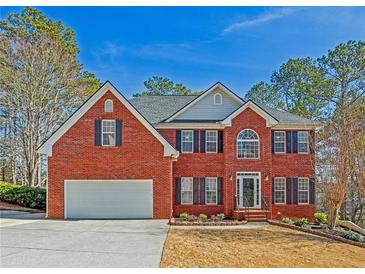 Charming two-story brick home with a well-maintained lawn, attached garage, and beautiful landscaping at 569 Alexander Farms Sw Vw, Marietta, GA 30064