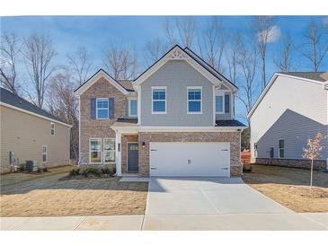 Charming two-story home featuring a brick facade, attached two-car garage, and nicely manicured lawn at 90 Barge Ln, Covington, GA 30016