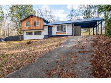 Charming split-level home with a unique carport and updated facade, nestled in a serene, wooded setting at 130 Valley Rd, Stockbridge, GA 30281