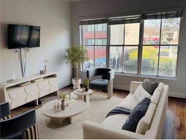 Cozy living room featuring hardwood floors, a large window, and neutral-toned furnishings at 384 Ralph Mcgill Ne Blvd # 121, Atlanta, GA 30312