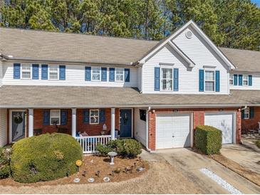 Charming townhome with brick accents, a covered porch, well-manicured landscaping, and attached garage at 330 Cottonwood Creek Cir, Canton, GA 30114
