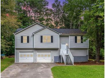 Two story home with light gray siding, black shutters, two-car garage and landscaping at 152 Country Cottage Cir, Carrollton, GA 30116