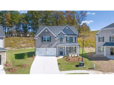 Charming two-story home with a two car garage, neutral paint and manicured landscaping at 1858 Lacebark Elm Way, Lawrenceville, GA 30045