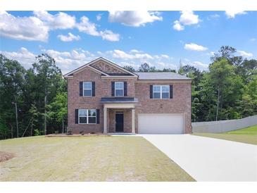 Charming two-story brick home with a well-manicured lawn and an attached two-car garage at 5417 Flat Rock Pt, Stonecrest, GA 30038