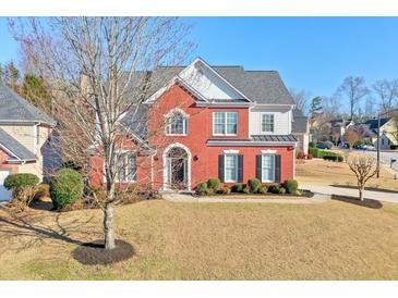 Charming red brick two-story home boasts a well-manicured lawn and mature landscaping at 251 Vinings Retreat Sw Vw, Mableton, GA 30126