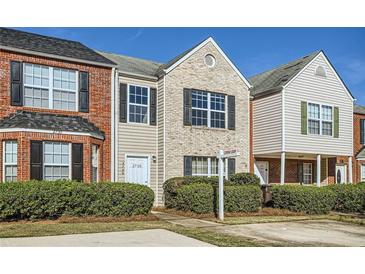 Traditional townhome with manicured landscaping and contrasting brick and beige facade at 2720 Marlin Dr, Mcdonough, GA 30253