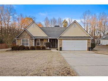 Charming single-story home with stone accents, a well-manicured lawn, and an attached two-car garage at 129 Windy Cir, Mcdonough, GA 30253