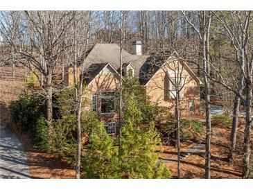 A charming brick home is nestled among mature trees, creating a private, serene setting at 4411 Windsor Oaks Cir, Marietta, GA 30066