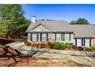 Charming single-story home featuring a brick facade, green shutters, and well-maintained landscaping at 1130 Camry Cir, Dallas, GA 30157