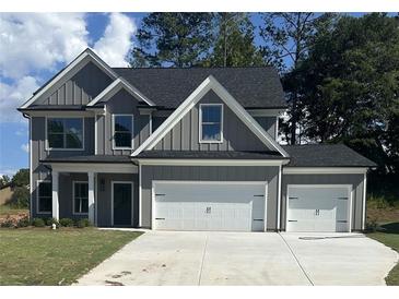 Charming new construction home featuring a three-car garage, board and batten siding, and a manicured lawn at 3086 Zodiac Ct, Lawrenceville, GA 30044
