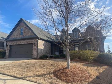 Charming brick home featuring an attached two-car garage and a well-manicured front yard with mature trees at 624 Hemlock Trl, Canton, GA 30114