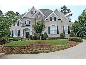 Stately home featuring a stone accent wall and manicured front lawn, plus a circular driveway at 120 Pine Mist Cir, Alpharetta, GA 30022