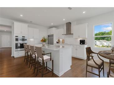 Bright kitchen features white cabinetry, stainless steel appliances, and a large island with bar seating at 237 Kindness Cir, Mcdonough, GA 30252