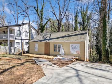 Exterior view of a home under construction showing a newly built deck and freshly poured concrete driveway at 1038 Orlando Sw Pl, Atlanta, GA 30311