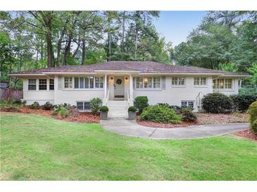 Charming one-story home featuring a landscaped front yard with a walkway leading to the front door at 850 Moores Mill Nw Rd, Atlanta, GA 30327